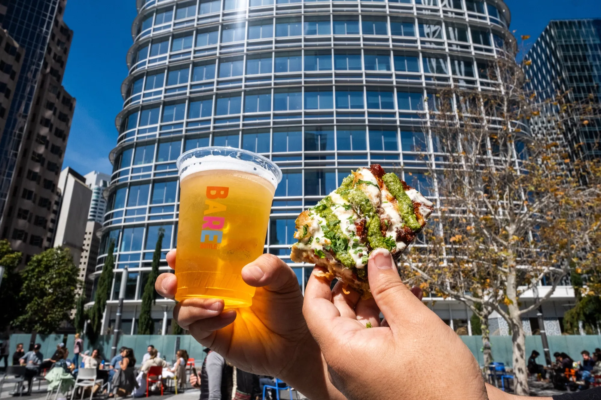 Beer and pizza with the round Salesforce Transit Center behind