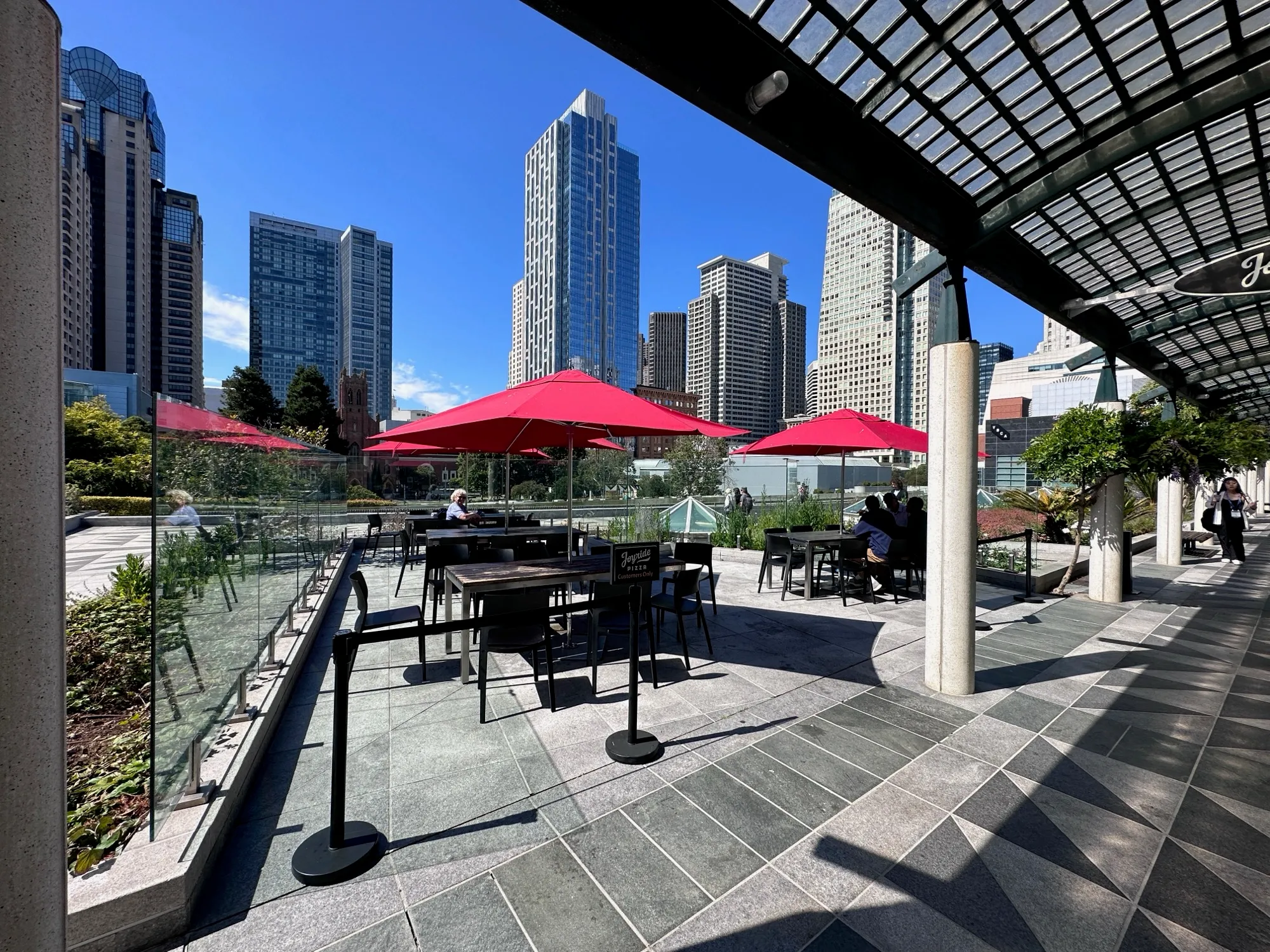 Outdoor patio with red umbrellas and the SoMa skyline